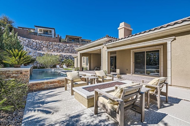 view of patio / terrace featuring an outdoor fire pit and an outdoor pool