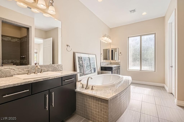 bathroom featuring a garden tub, visible vents, a sink, and tiled shower