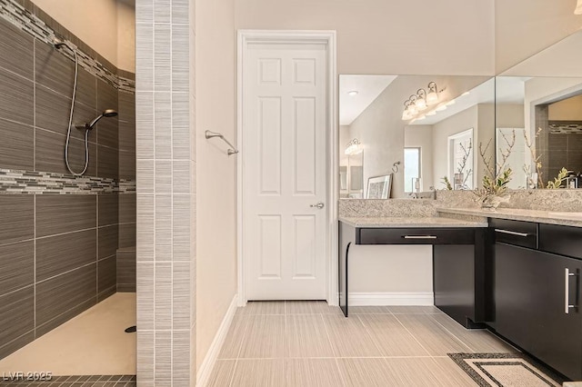 full bathroom featuring baseboards, a walk in shower, and vanity