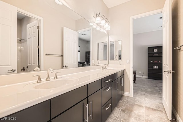 full bath with a sink, baseboards, and double vanity