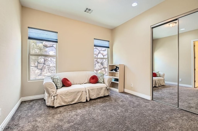 living area featuring carpet floors, visible vents, and baseboards