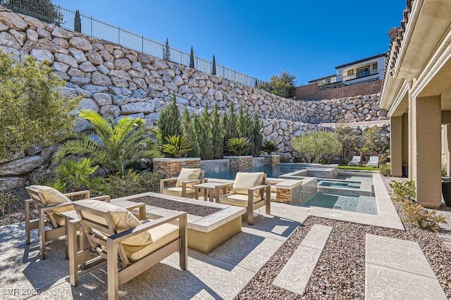 view of patio featuring an in ground hot tub, an outdoor fire pit, fence, and an outdoor pool