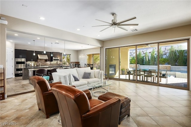 living area featuring a wealth of natural light, visible vents, ceiling fan, and recessed lighting