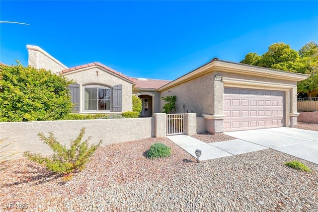 view of front of property featuring a fenced front yard, concrete driveway, an attached garage, and stucco siding