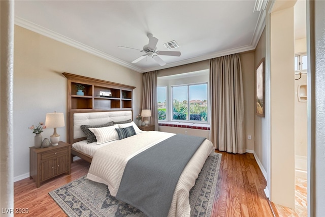 bedroom with visible vents, baseboards, a ceiling fan, ornamental molding, and light wood-type flooring