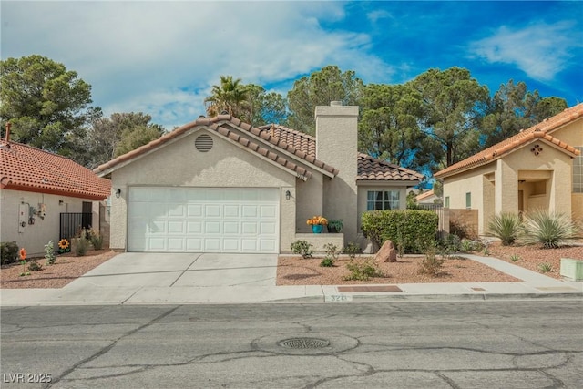 mediterranean / spanish home with a tile roof, a chimney, stucco siding, an attached garage, and driveway