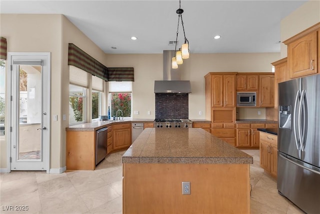 kitchen with a center island, recessed lighting, stainless steel appliances, wall chimney range hood, and tile counters