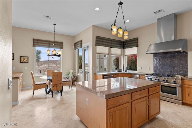 kitchen featuring visible vents, tile counters, appliances with stainless steel finishes, wall chimney exhaust hood, and tasteful backsplash