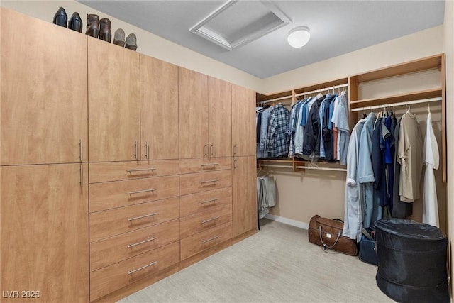 spacious closet with attic access and light carpet