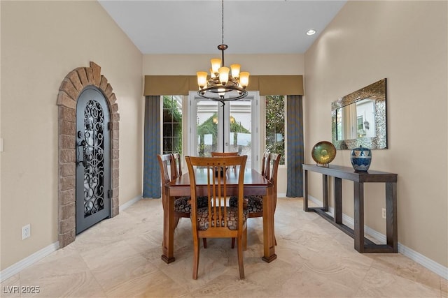 dining space featuring a notable chandelier and baseboards