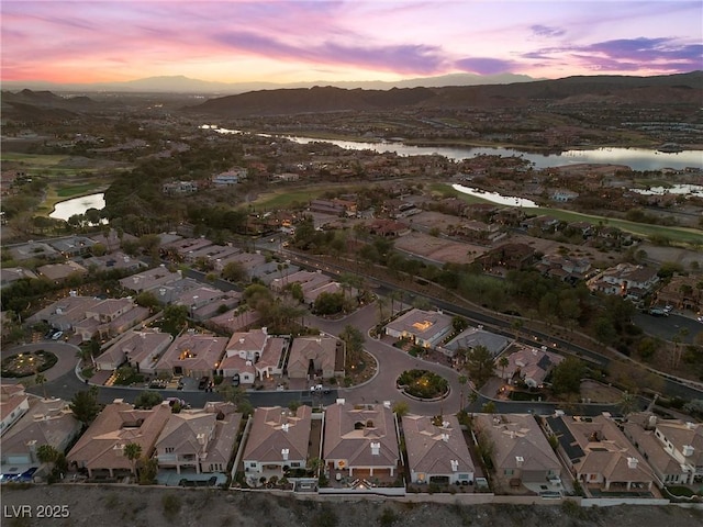 aerial view at dusk featuring a residential view and a water and mountain view