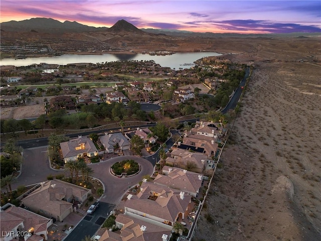 aerial view at dusk featuring a residential view and a water and mountain view