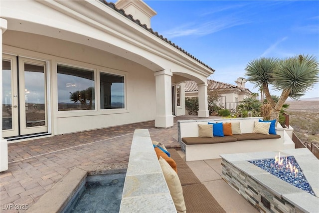 view of patio featuring french doors and an outdoor living space with a fire pit