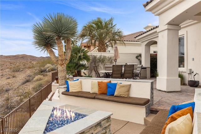 view of patio / terrace with outdoor dining area, an outdoor living space with a fire pit, and a mountain view