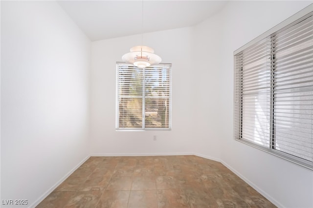 unfurnished dining area with vaulted ceiling and baseboards