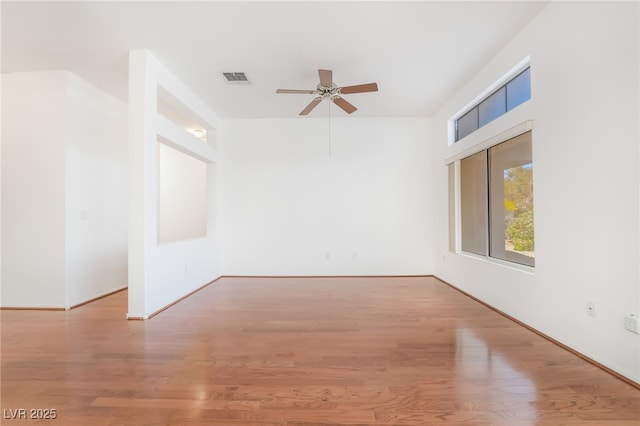 spare room featuring visible vents, wood finished floors, and a ceiling fan