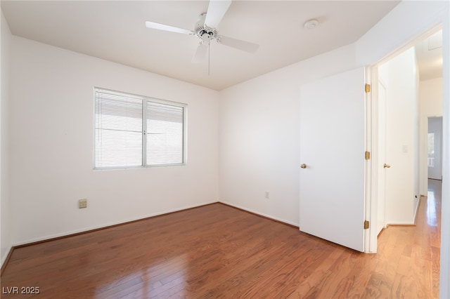 unfurnished room with light wood-style floors, baseboards, and a ceiling fan