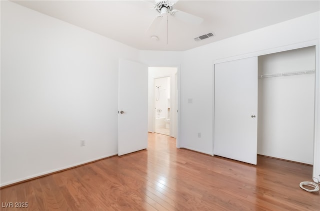 unfurnished bedroom featuring ceiling fan, light wood-style flooring, a closet, and visible vents