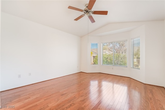 unfurnished room featuring vaulted ceiling, a ceiling fan, and light wood-style floors