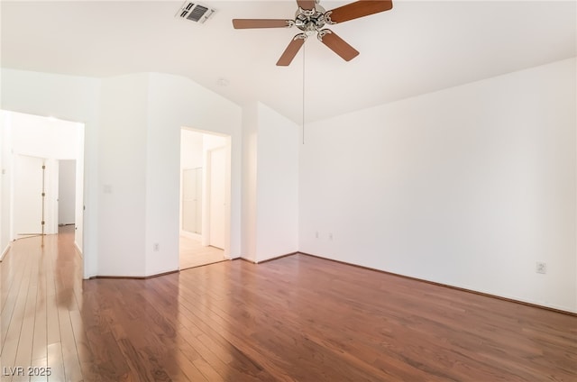 unfurnished room with lofted ceiling, a ceiling fan, visible vents, and wood finished floors