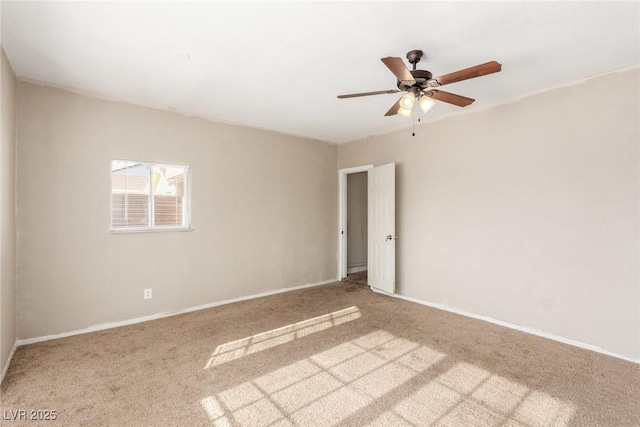 carpeted empty room with a ceiling fan and baseboards