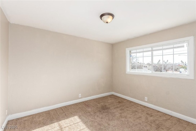 carpeted spare room featuring baseboards