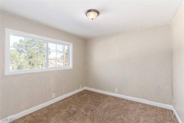 spare room with carpet and baseboards