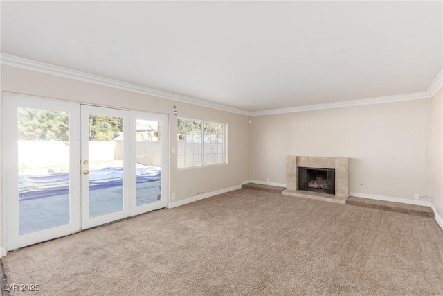 unfurnished living room with ornamental molding, a high end fireplace, carpet flooring, and baseboards