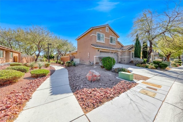 view of side of property with a garage, concrete driveway, a tiled roof, fence, and stucco siding