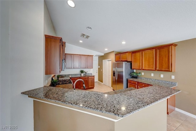 kitchen featuring vaulted ceiling, appliances with stainless steel finishes, stone countertops, and visible vents