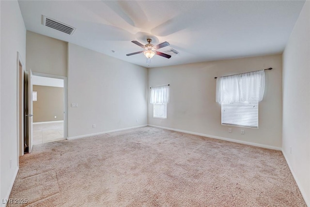 empty room featuring baseboards, carpet floors, visible vents, and a ceiling fan