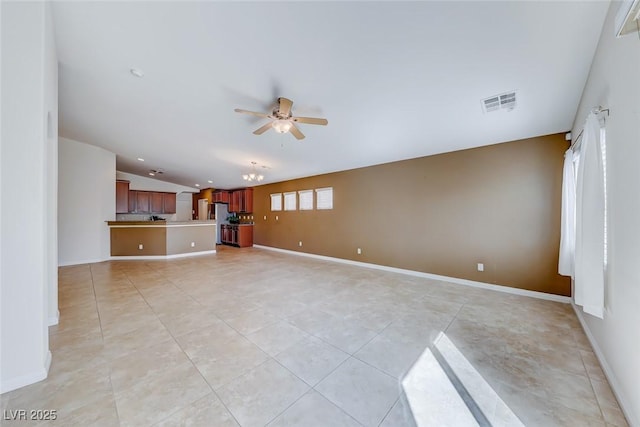 unfurnished living room featuring lofted ceiling, visible vents, light tile patterned flooring, ceiling fan, and baseboards