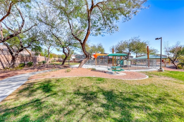 view of yard featuring playground community and fence