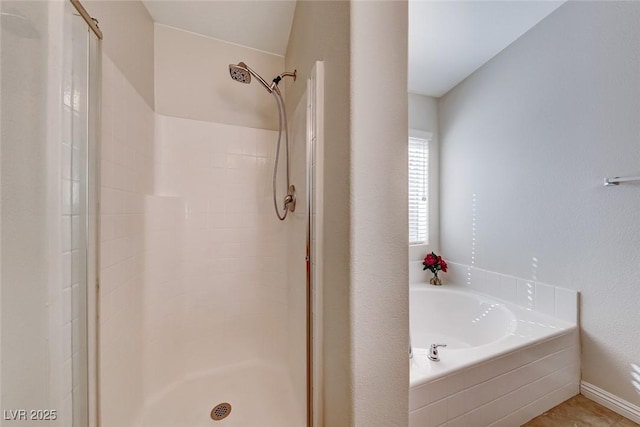 full bathroom featuring a stall shower and a garden tub