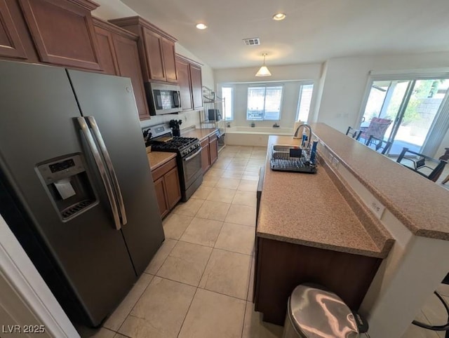 kitchen featuring light tile patterned floors, a kitchen island with sink, recessed lighting, visible vents, and appliances with stainless steel finishes