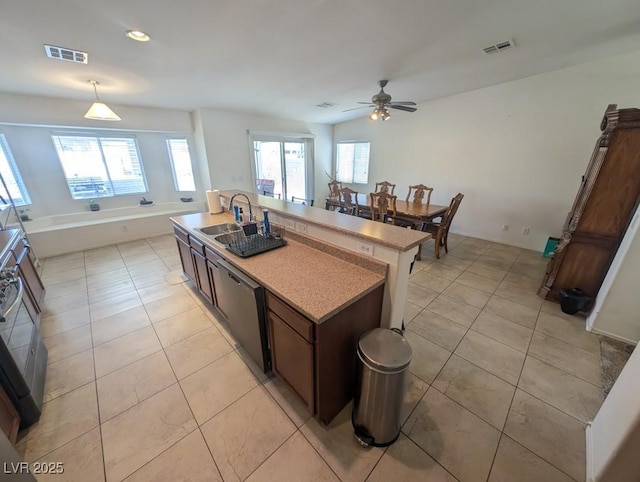 kitchen featuring dishwasher, light tile patterned floors, a sink, and visible vents