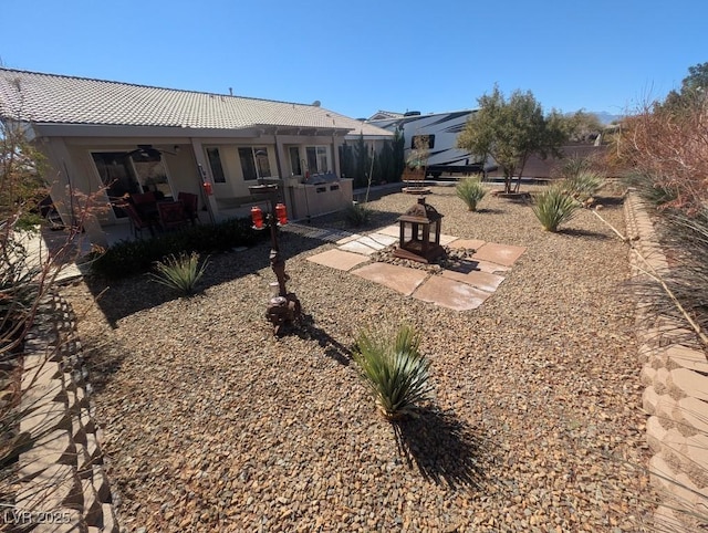 back of house with ceiling fan and a patio