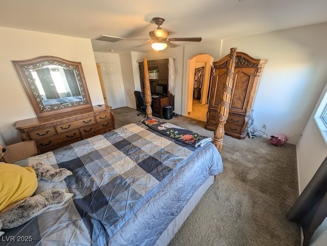 bedroom with carpet flooring, visible vents, a ceiling fan, a spacious closet, and a closet