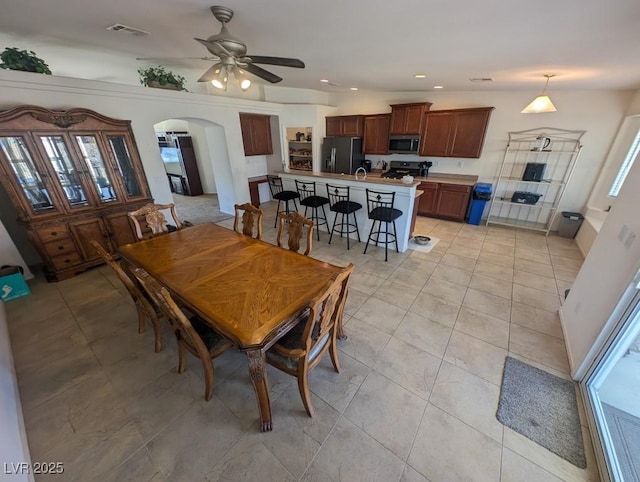 dining area with arched walkways, light tile patterned floors, recessed lighting, visible vents, and ceiling fan