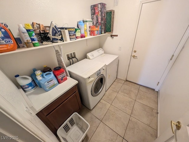 laundry room with light tile patterned flooring, cabinet space, and washer and dryer