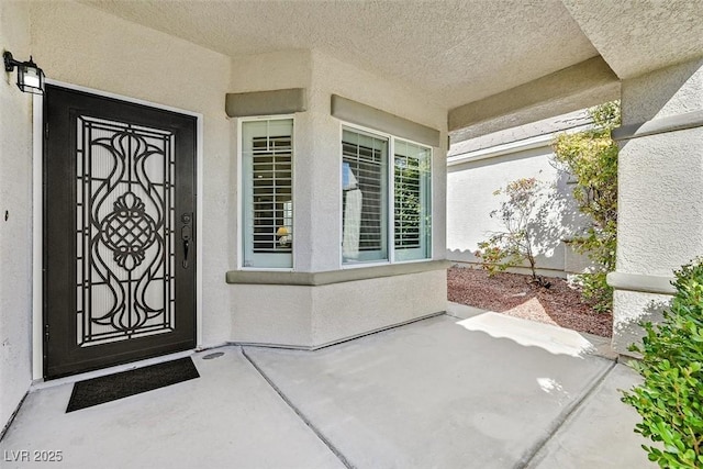 entrance to property with a patio and stucco siding