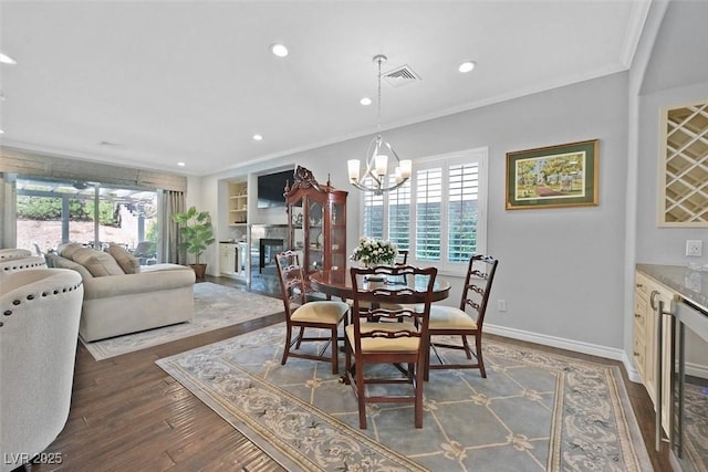 dining room featuring wine cooler, dark wood finished floors, crown molding, a wealth of natural light, and visible vents