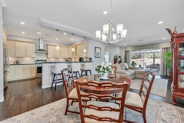 dining area featuring an inviting chandelier, ornamental molding, dark wood-style flooring, and recessed lighting