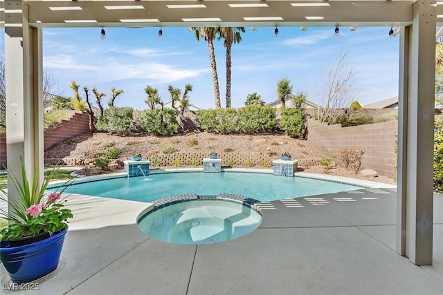 view of swimming pool with a pool with connected hot tub, a patio area, and fence