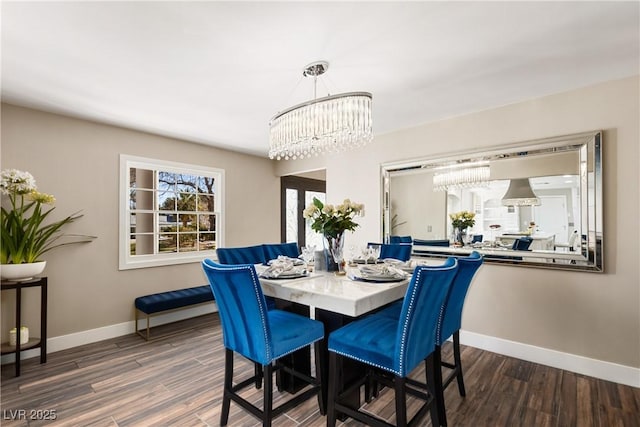 dining space with a chandelier, wood finished floors, and baseboards