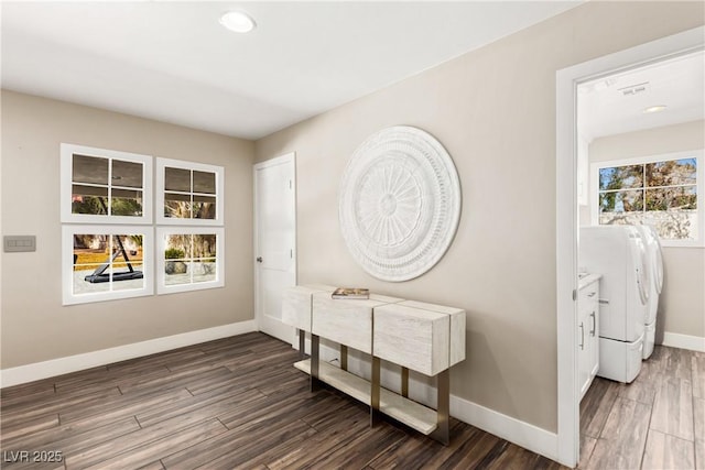 interior space featuring wood finished floors, washing machine and clothes dryer, visible vents, and baseboards