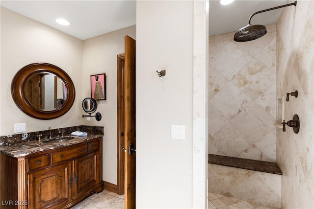 full bath with a tile shower and vanity