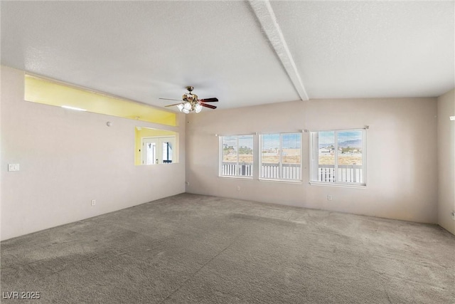 carpeted empty room featuring a textured ceiling, beamed ceiling, and a ceiling fan