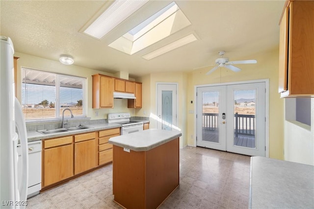 kitchen with light floors, white appliances, a sink, and under cabinet range hood