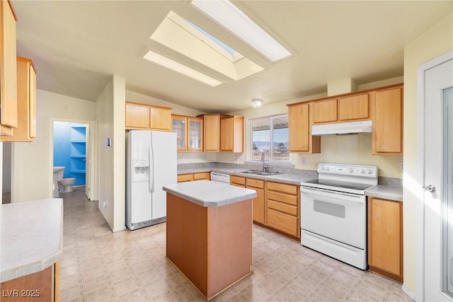 kitchen with light brown cabinets, under cabinet range hood, white appliances, a sink, and light floors